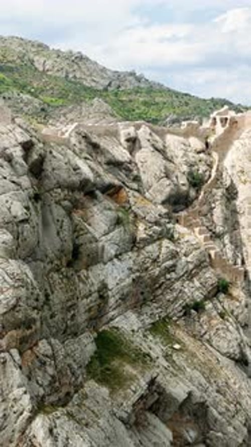 Vue aérienne par drone d'une forteresse historique construite le long de falaises spectaculaires surplombant un canyon v