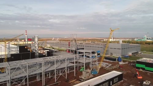 Carcasa metálica y grúa de torre amarilla en el sitio de construcción
