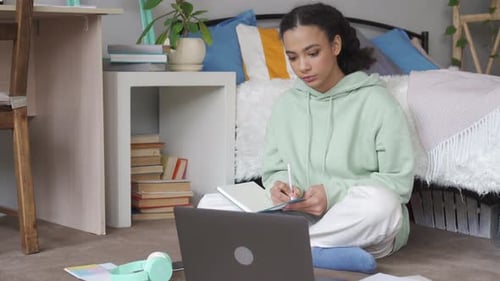 African teen schoolgirl watching remote education live stream at home