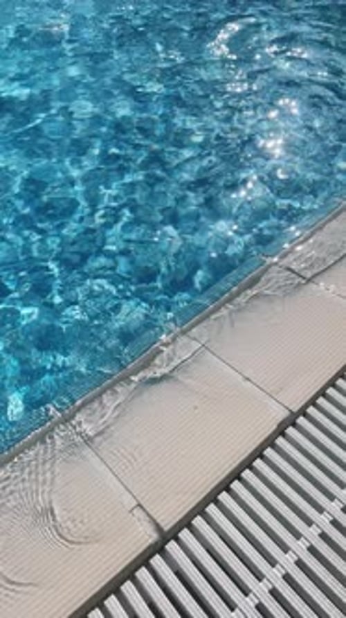 Reines blaues Wasser im Pool mit Lichtreflexen, vertikale Zeitlupenaufnahmen