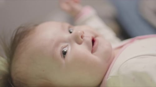 Adorable Newborn Baby Girl Lying in a Crib