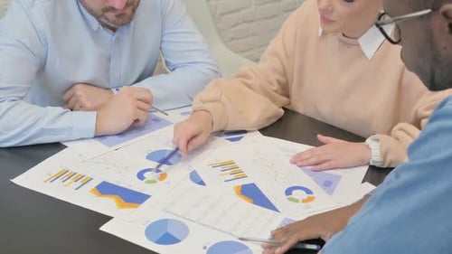 Close up of Woman Discussing Business Report with Teammates
