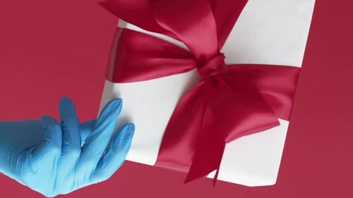 Gloved Hand Holding a Gift Box