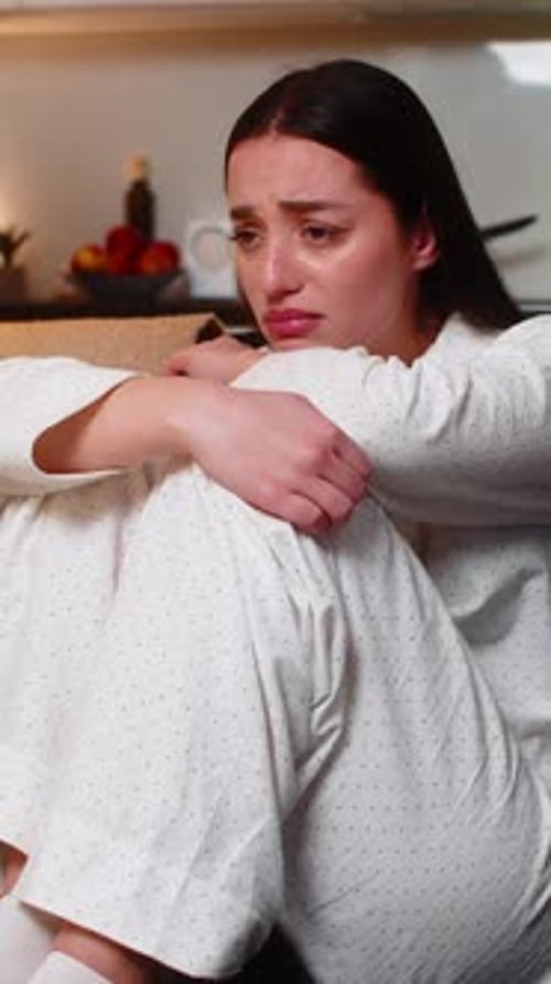 Woman Sitting Crying on Sofa in Home Interior