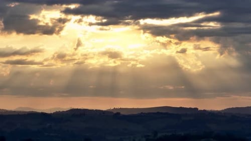 Golden Sun Rays Bursting Through Cloudy Landscape