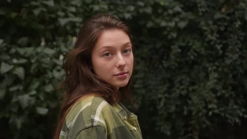 Young Woman Turns Toward Camera Outdoors