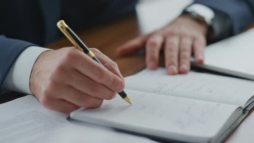 Executive Manager Making Notes in Notebook at Office Close Up