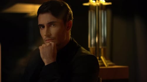 Contemplative young man with dark hair in dim light