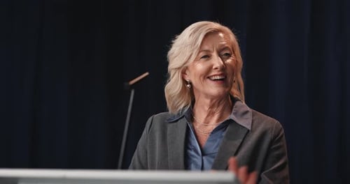 Businesswoman at Podium Giving Presentation