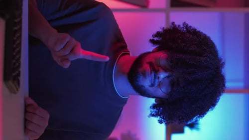 Person Pointing at Camera in Neon Lit Room