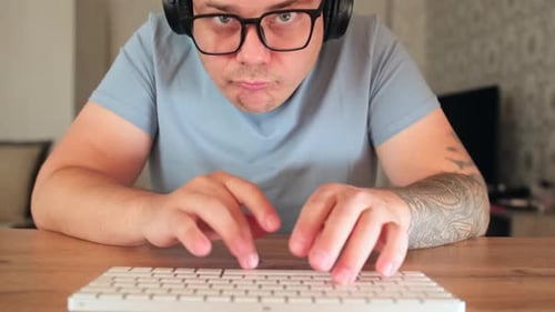 Focused Adult Types at Keyboard at Home