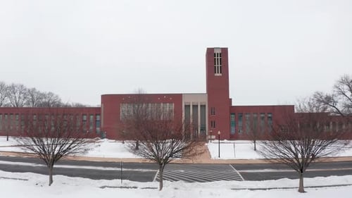 Vue aérienne prise par un drone d'une grande école en brique, d'un collège, d'une université recouverte de neige. Winter Storm Car