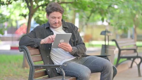 Man Using Tablet on Park Bench
