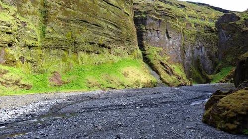 Dynamic aerial shot above the bottom of the ravine. Canyon of Stakkholtsgja in Iceland.