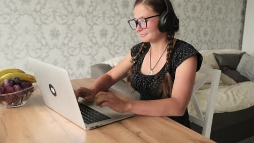 Woman Working on Laptop at Table Indoors