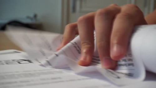 Hand Crumples Paper into a Ball