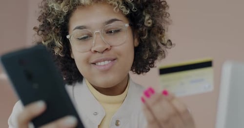 Happy African American Lady Shopping with Smartphone Buying in Online Store Paying with Credit Card