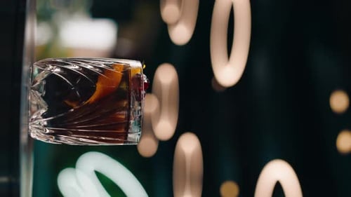 vertical video freshly prepared black alcoholic cocktail rotates on the bar counter in the bar-club