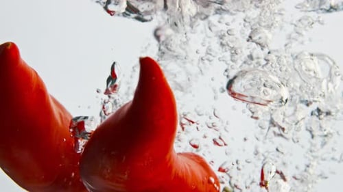 Red Peppers Splashing Liquid Closeup