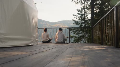 Couple Meditating on Deck in Rural Mountain Setting