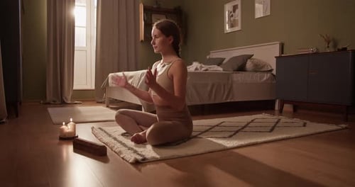 Woman Meditating Peacefully Indoors with Candles