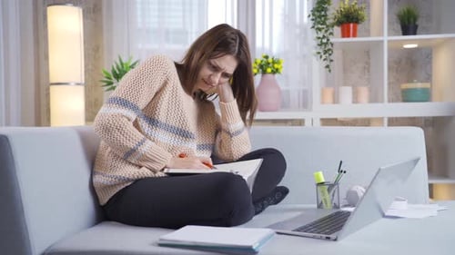 Young college girl resting and studying on sofa at home.