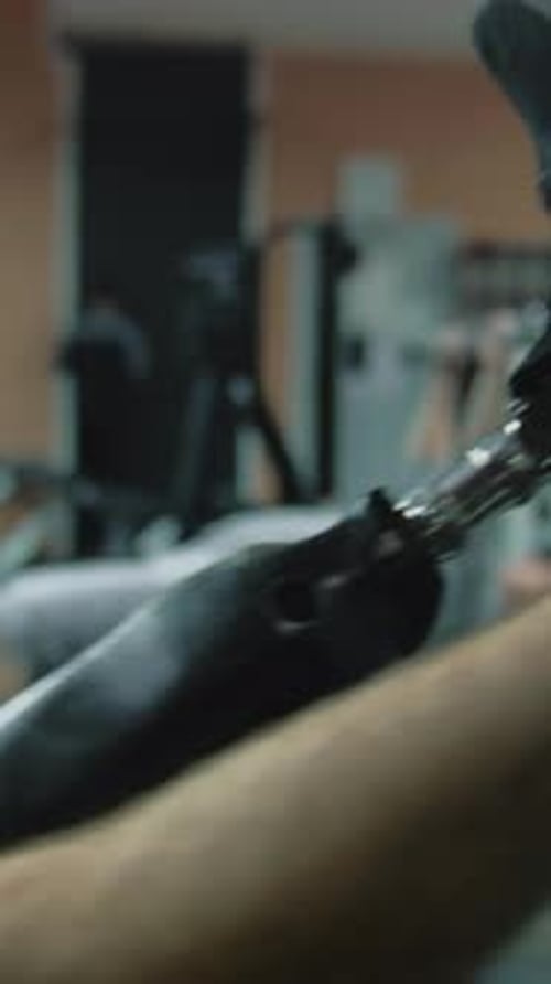 Sportsman with Prosthetic Leg Exercising on Leg Press Machine in Gym