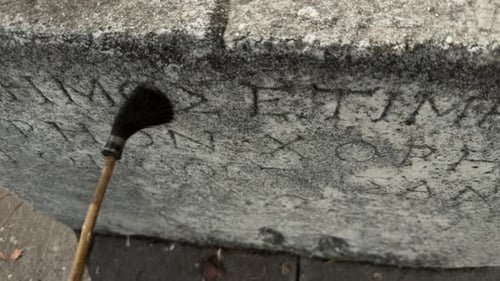 Ancient Stone Inscription Being Cleaned with Brush