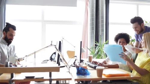 Happy multiethnic startup team discussing project in modern office