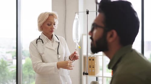 Elderly Woman in Lab Coat Testing Dropper with Solution for Chemotherapy