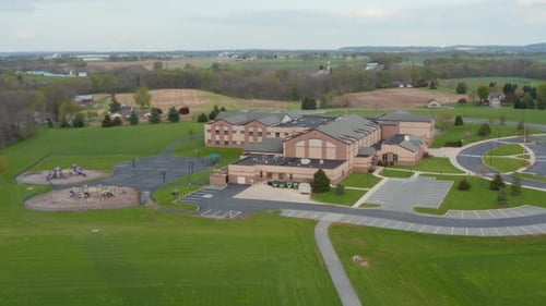 Vue aérienne d'un bâtiment scolaire américain moderne aux États-Unis. L'éducation en Amérique. Terrain de jeu et terres agricoles rurales