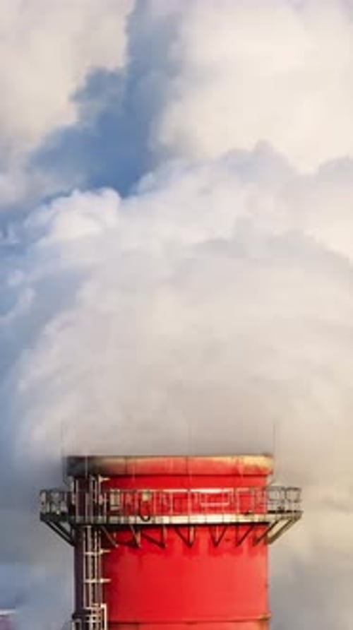 Industrial Chimney Emitting White Smoke on Bright Day