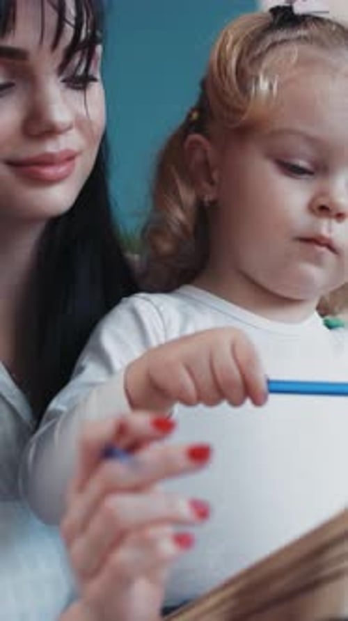 A Young Girl Engaged in a Creative Painting Activity Using a Brush During a Colorful Art Session