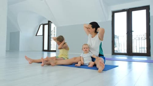 Mother and Children Exercising Together in Bright Room