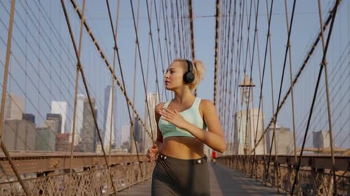 Young woman running outdoors on a modern bridge