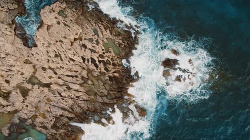 Aerial View of Waves Crashing Rocky Shoreline