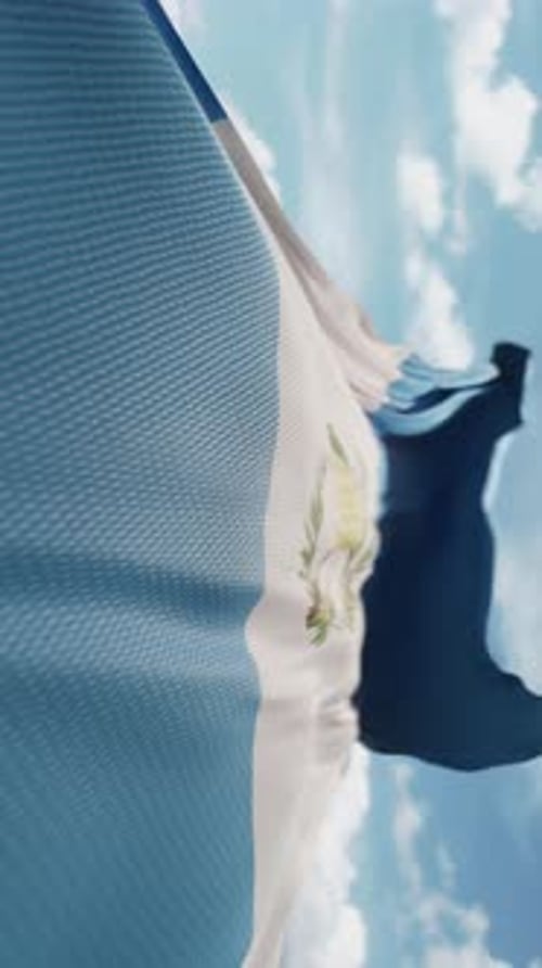 Realistic Waving Flag of Guatemala Against Blue Sky