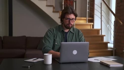 Young Businessman Working with Laptop and Typing While Sitting at Table in Home Office Spbas