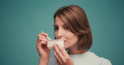 Woman enjoying a delicious yogurt snack in studio