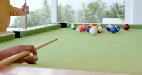 Player is placing cue ball, aligning stick and striking to break colored balls on pool table