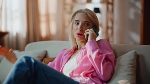 Woman Talking on Phone While Sitting on Couch