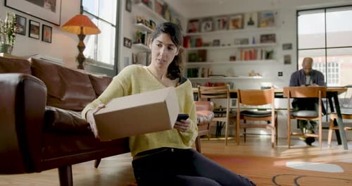 Woman with Box Using Phone in Bright Living Room