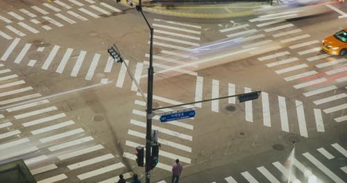Intersección de tráfico capturada desde arriba que muestra vehículos moviéndose por los cruces peatonales y el tráfico