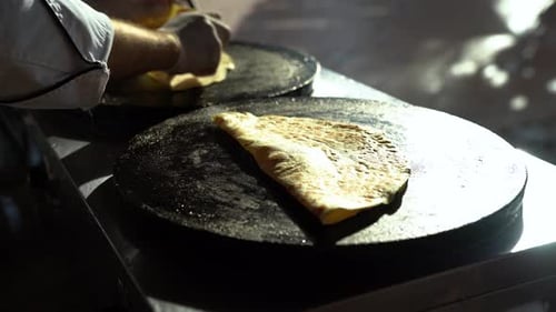 The Cook Sprinkles the Flatbread with Sweet Powder and Chocolate Cream