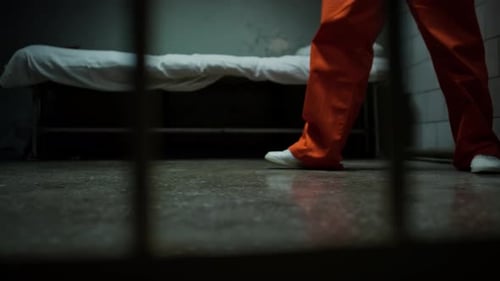 Legs of Anxious Inmate Pacing around Prison Cell
