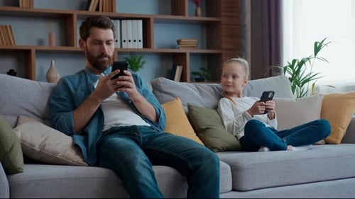 Man and Girl on Couch Using Mobile Phones