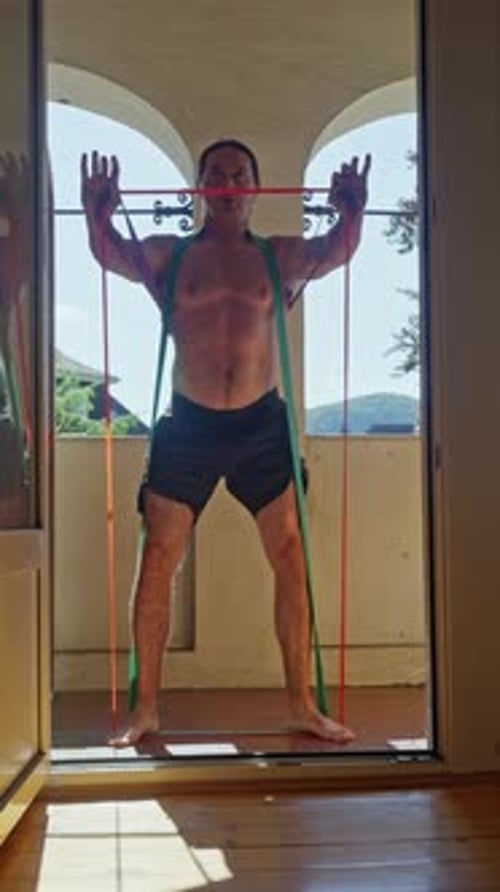 Man Exercises at Home with Resistance Bands