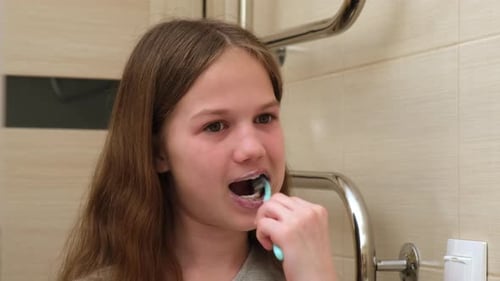 Kid Girl Brushing Teeth in Bathroom Close Up