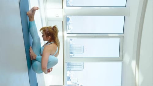 Tela vertical: mulher iogue praticando pose estendida de agachamento com as pernas para frente ou pistola