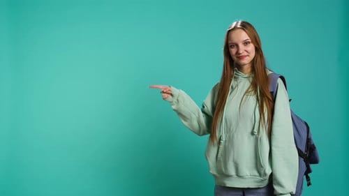 Smiling Woman Pointing to Copy Space with Backpack